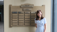 Chloe and the name plates of all recipients of the Cultus et Beneficentia Awards, on the ground floor of the College hostel
